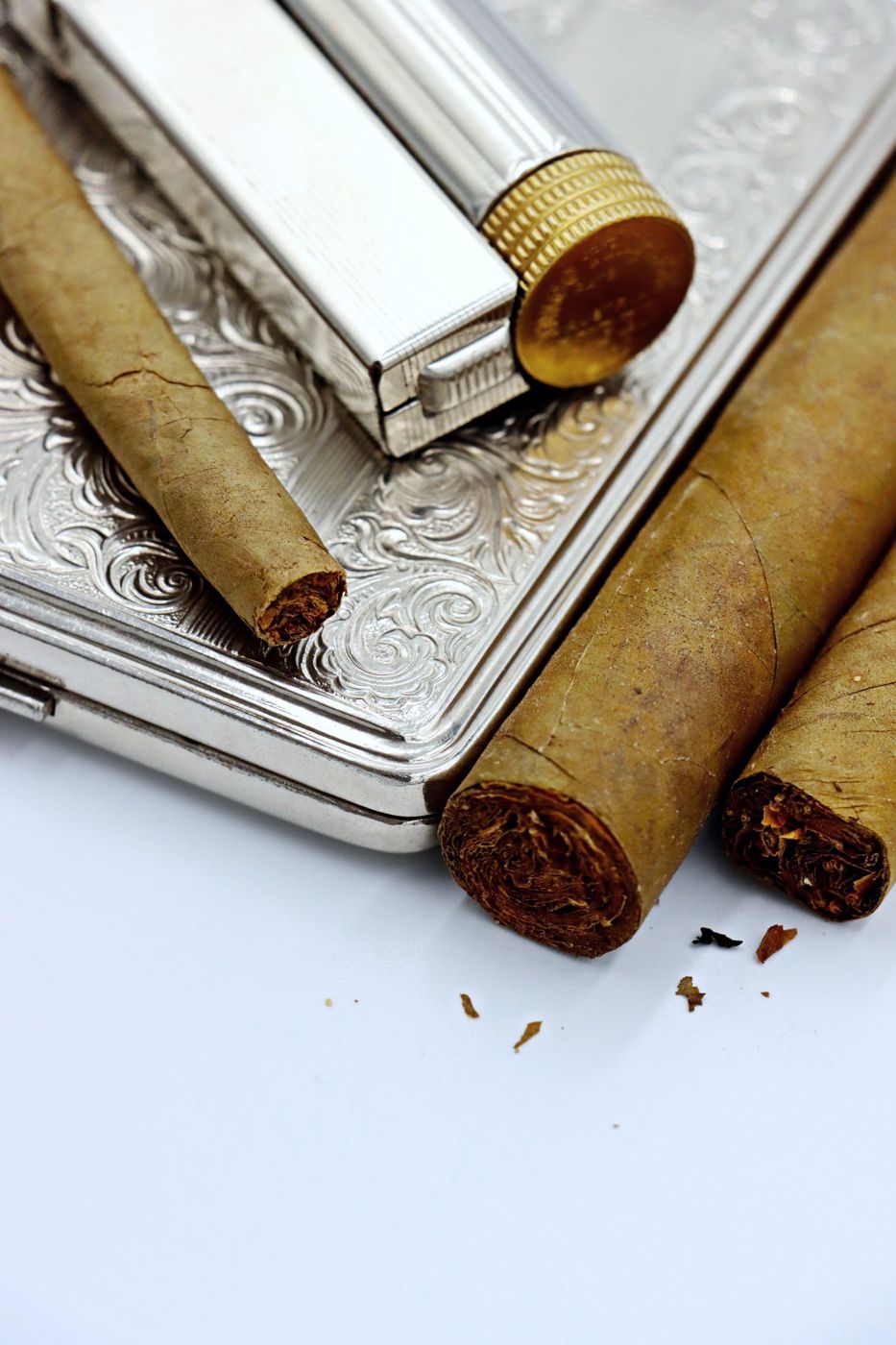 Cigars beside a silver lighter and case