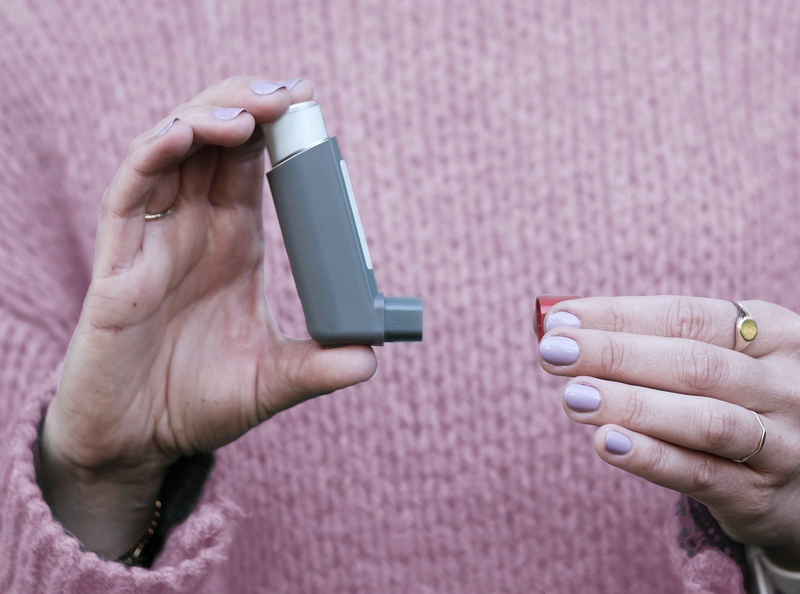 Hands holding an inhaler