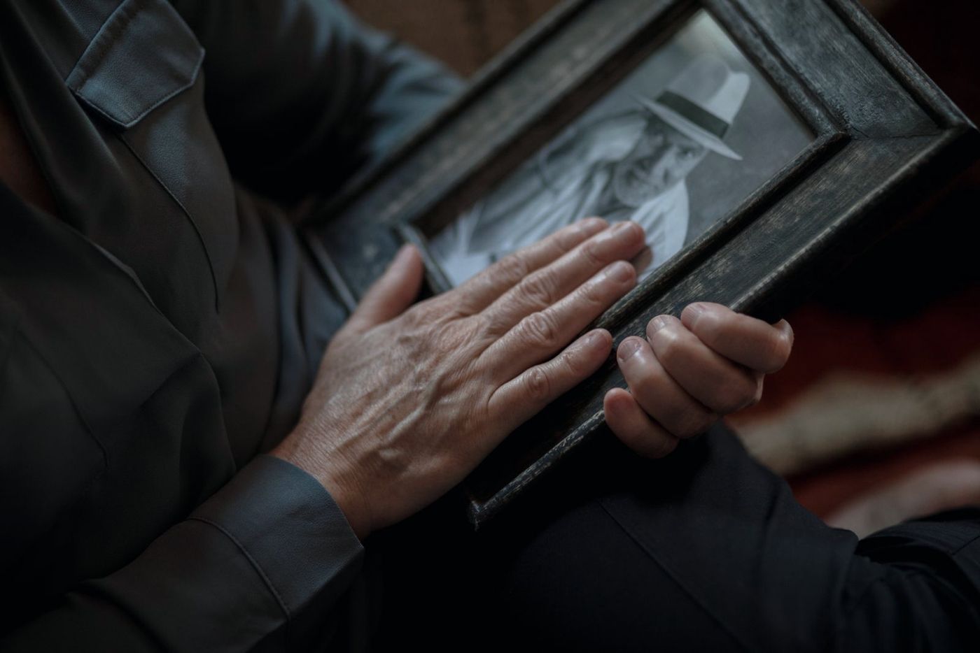 Hands holding an old framed photograph