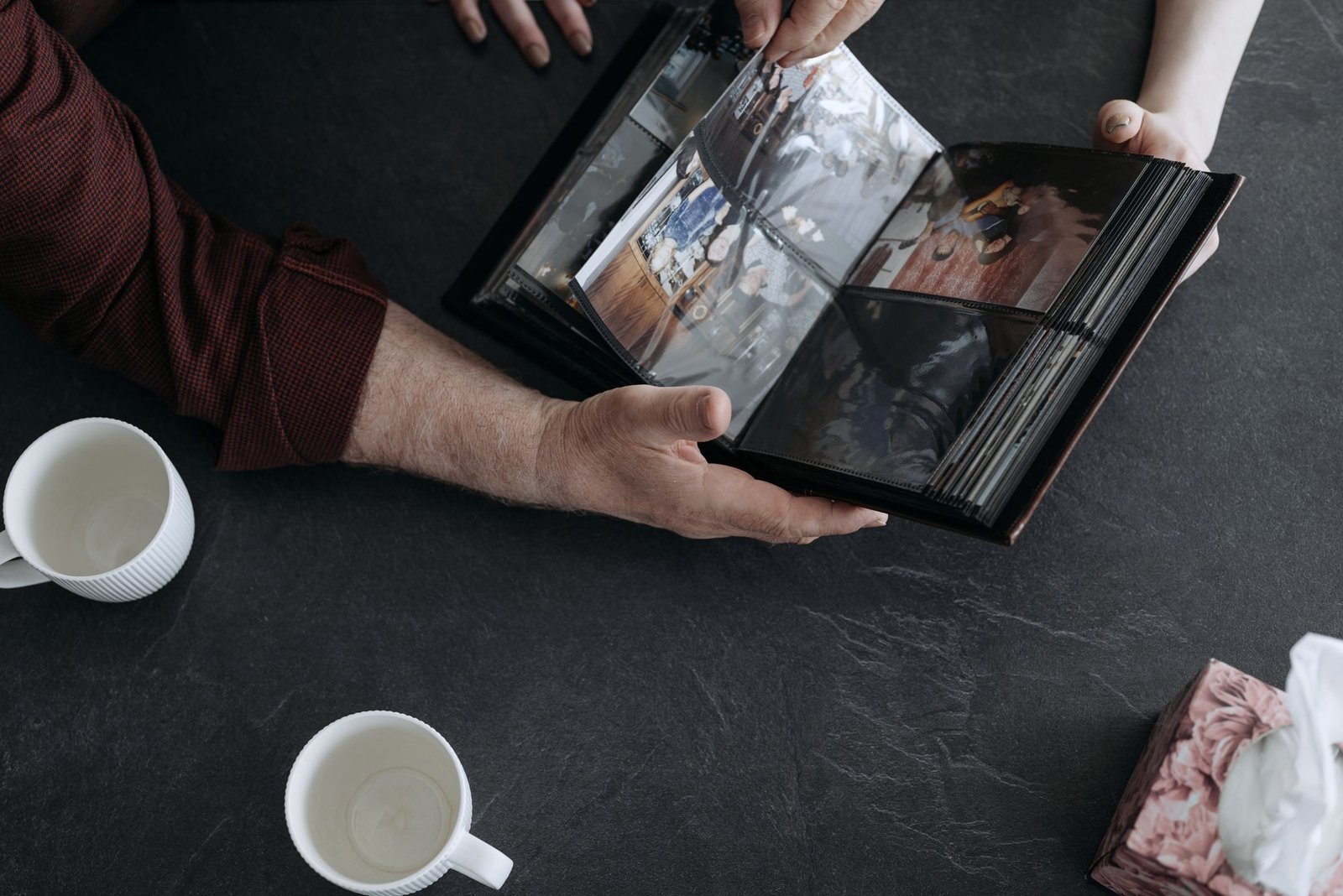 Hands turning the pages of an old photo album
